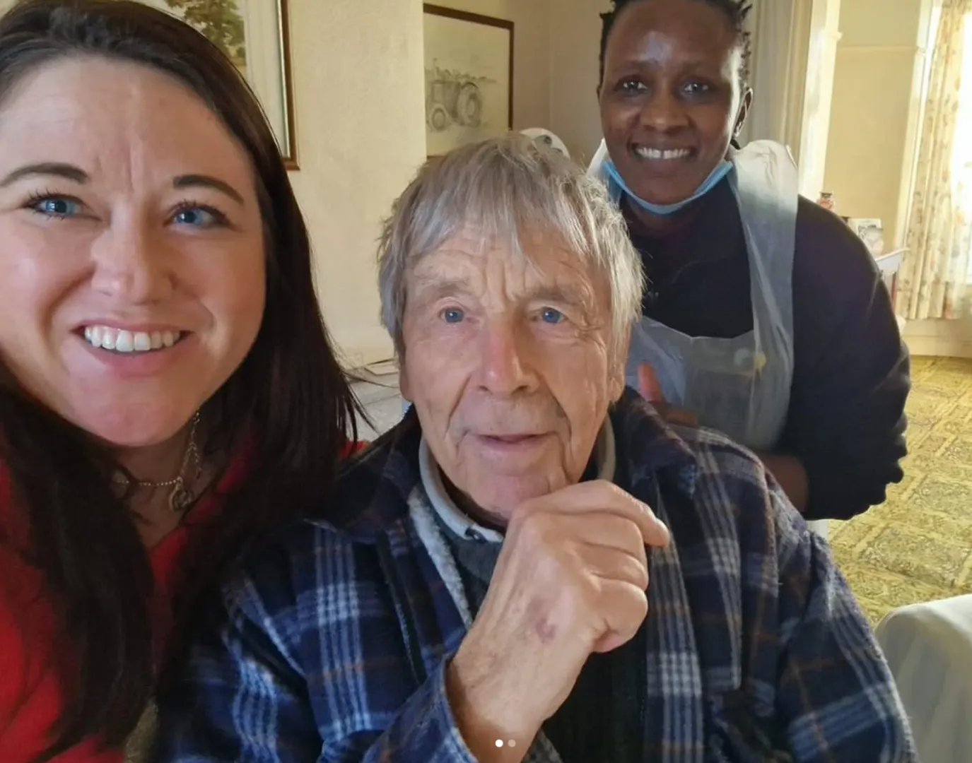Astar Homecare carer enjoying a coffee with a male client at a café table by the window.