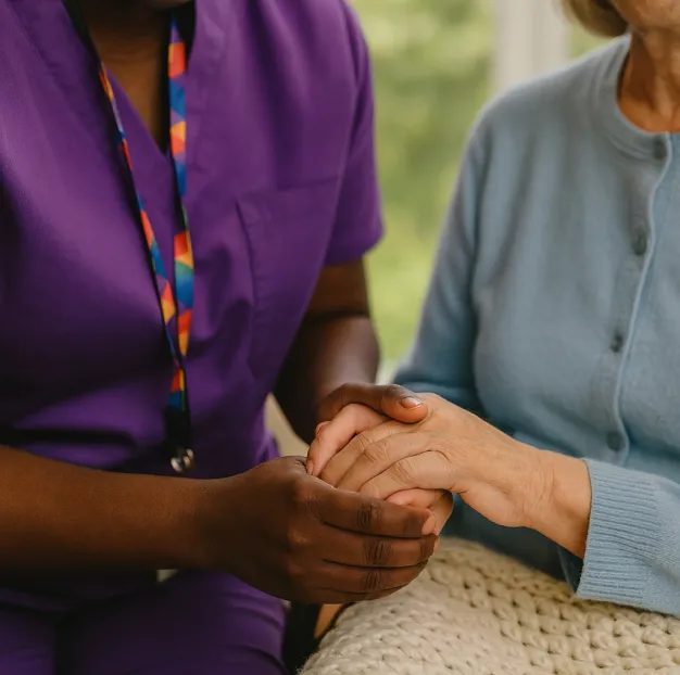 Astar Homecare carer providing gentle support, holding hands with a person receiving learning disability care at home.