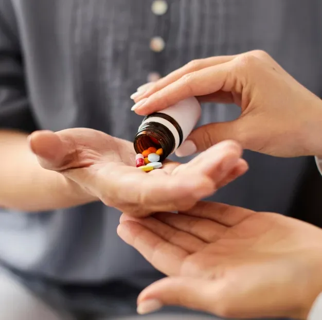 Astar Homecare carer providing daily medication support, handing pills to an elderly person to ensure safety and wellbeing.