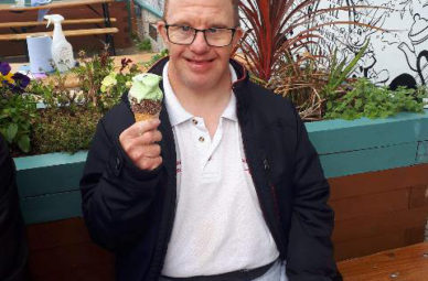 Man smiling holding up ice-cream
